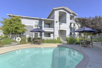 A swimming pool in front of a two-story building.